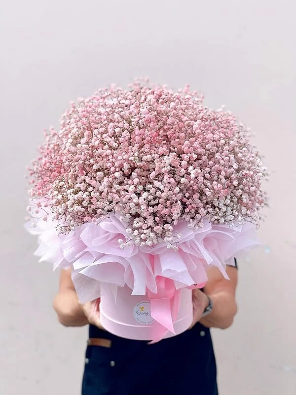 Một người phụ nữ cầm một bó hoa màu hồng ảnh hoa valentine