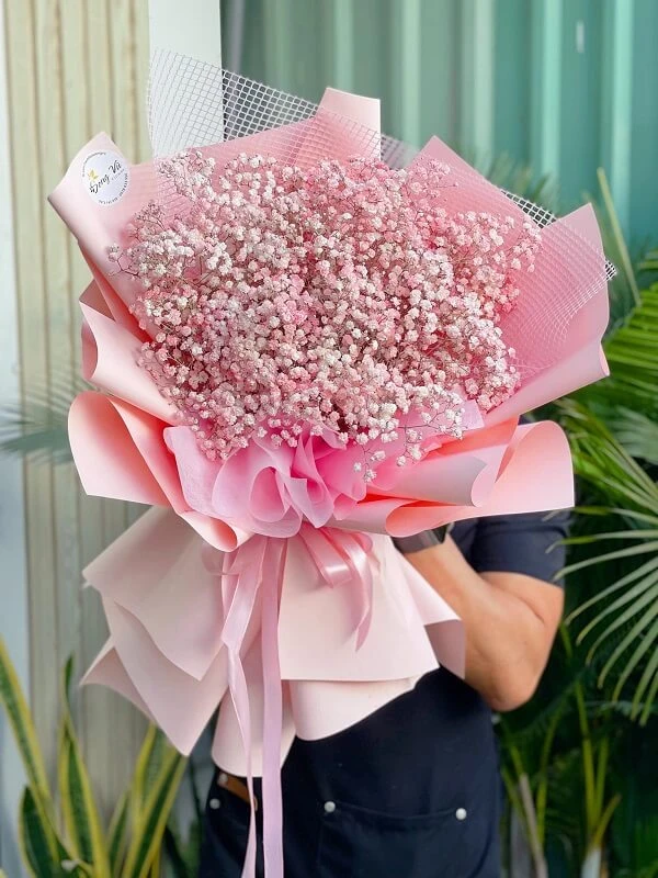 Một người phụ nữ cầm một bó hoa màu hồng ảnh hoa valentine