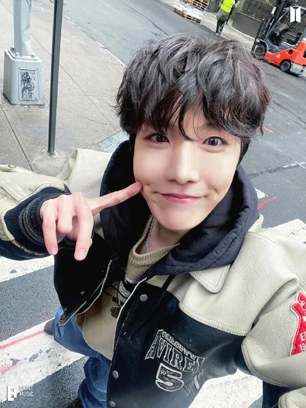 Ảnh j-hope bts có một người đàn ông đang đứng bên đường