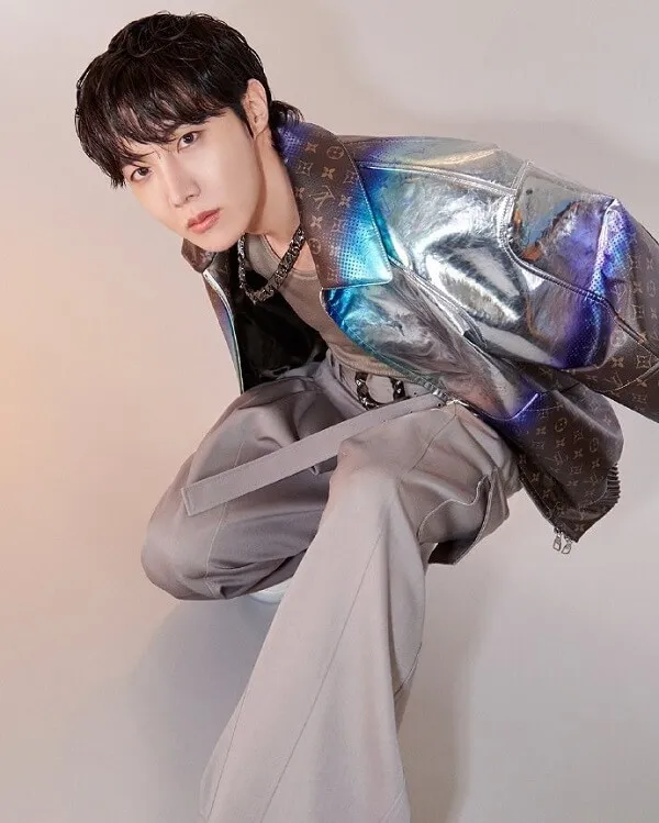 Ảnh j-hope bts có một người đàn ông đang ngồi trên ghế mặc áo khoác