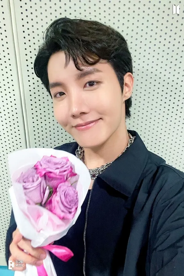 J-hope ảnh dìm có một người đàn ông cầm bó hoa hồng trong tay