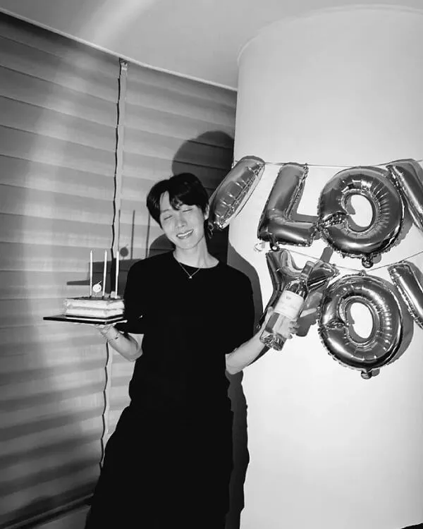 J-hope ảnh dìm đây là một bức đen trắng của người phụ nữ cầm bánh sinh nhật