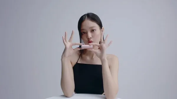 Ảnh jennie có một người phụ nữ ngồi bàn với điện thoại di động trước mặt