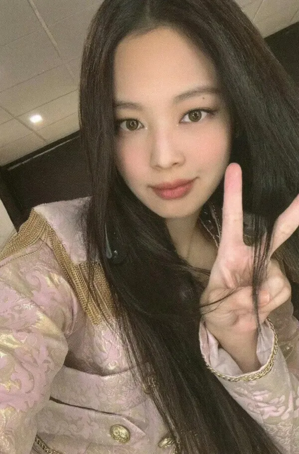 Ảnh jennie cute có một người phụ nữ đang tạo ra dấu hiệu hòa bình với ngón tay của mình