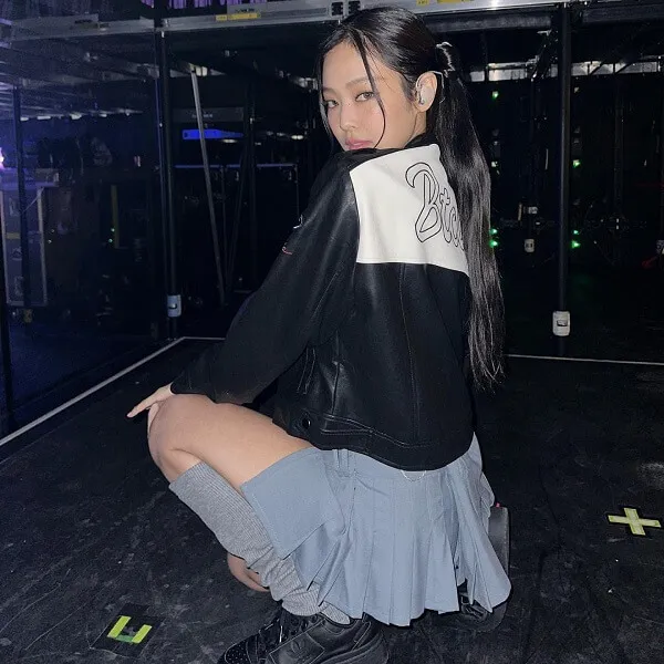 Ảnh jennie cute có một người phụ nữ quỳ trên mặt đất trong chiếc áo sơ mi đen trắng