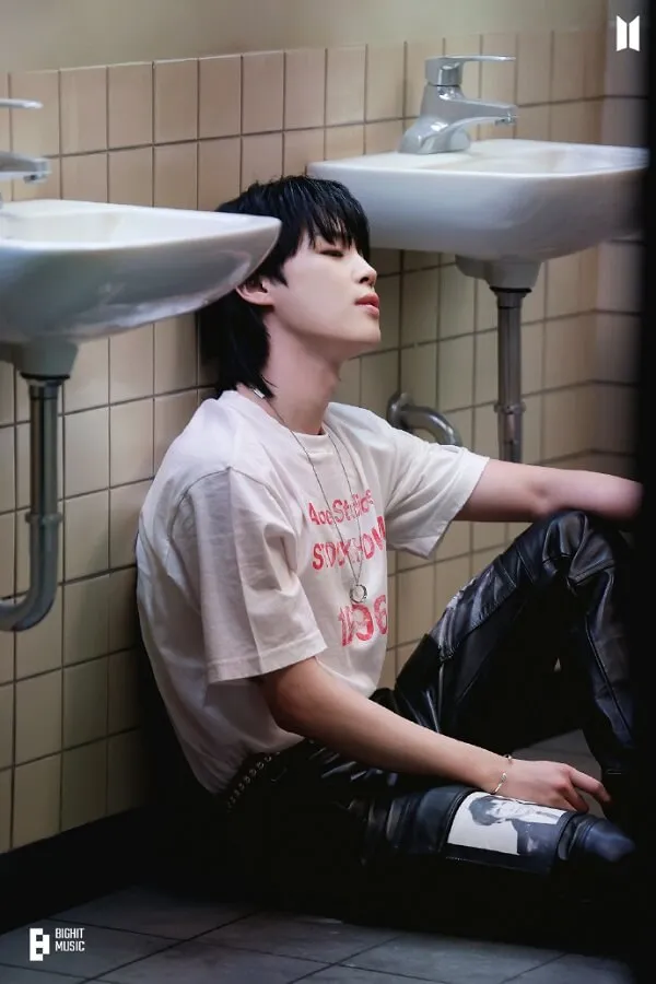 Ảnh jimin dễ thương có một chàng trai trẻ ngồi trên sàn trước bồn rửa