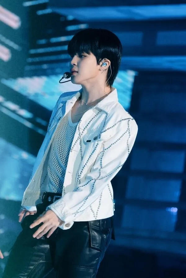 Ảnh jimin đời thường có một người đàn ông mặc áo sơ mi trắng và quần đen trên sân khấu