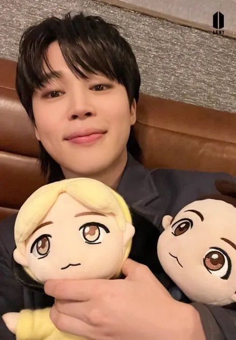 Ảnh jimin có một người phụ nữ cầm hai con búp bê nhồi bông trong tay