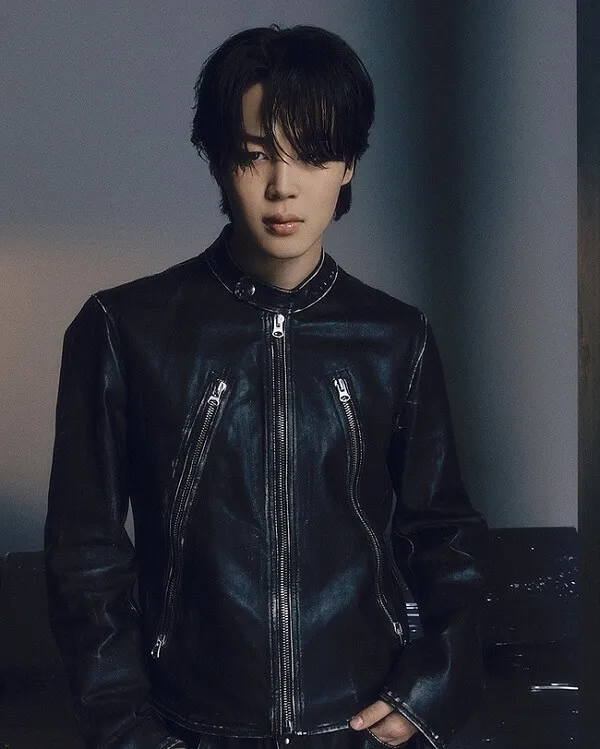 Ảnh jimin đời thường thanh niên mặc áo khoác da màu đen đứng trước tường