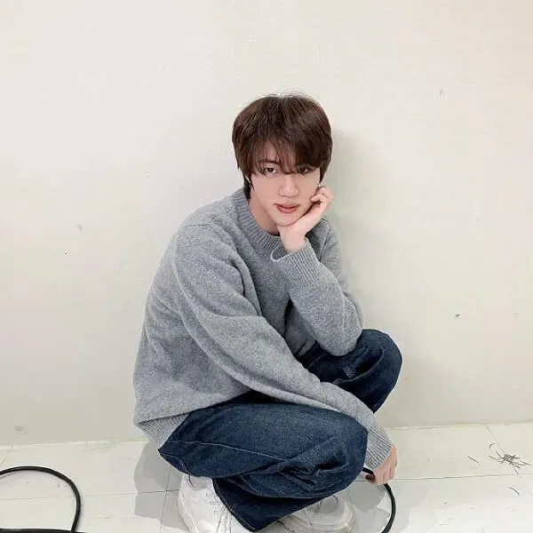 Ảnh jin bts ai đó đang ngồi trên sàn với tay của họ dưới cằm