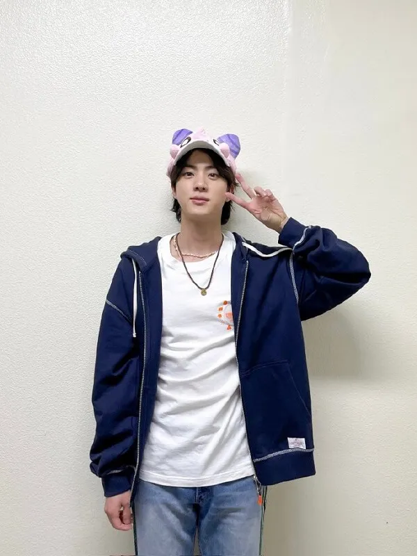 Ảnh jin bts có một chàng trai trẻ mặc áo khoác màu xanh và phông trắng