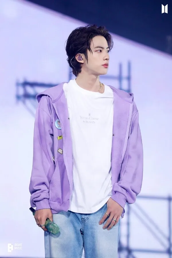 Ảnh jin bts đẹp anh ấy đang mặc một chiếc áo khoác màu tím và quần jean phông trắng