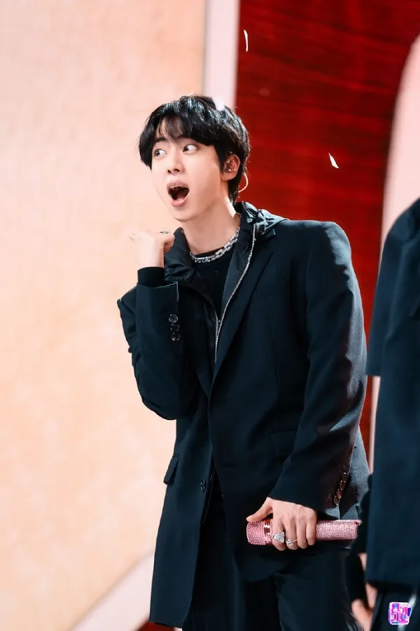 Ảnh jin bts đẹp có một người đàn ông mặc bộ đồ đen nói chuyện trên điện thoại di động