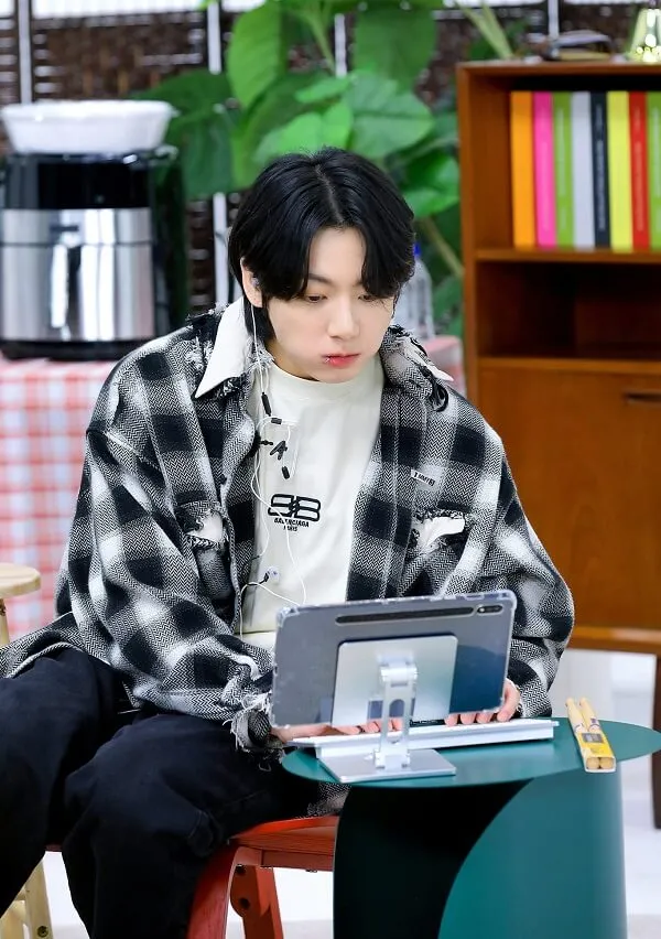 Ảnh jungkook cute có một chàng trai trẻ ngồi bàn với máy tính xách tay