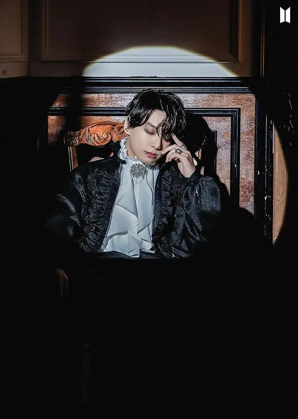 Ảnh jungkook có một người đàn ông đang ngồi trên ghế nói chuyện điện thoại