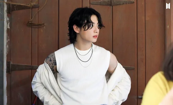 Ảnh jungkook có một người đàn ông đang đứng trước cánh cửa gỗ