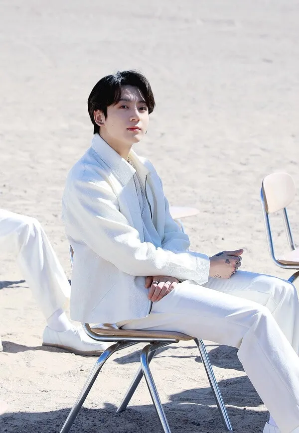 Ảnh jungkook đây là một người đàn ông ngồi trên ghế bãi biển