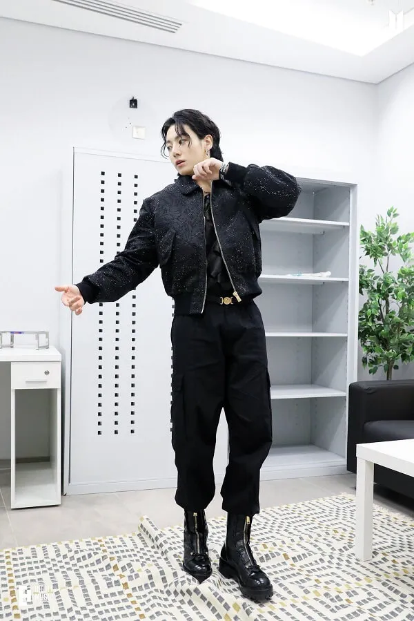 Ảnh jungkook ngầu có một người đàn ông đang đứng trong phòng khách nói chuyện trên điện thoại di động