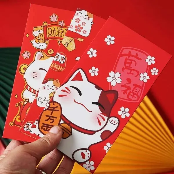Ảnh lì xì có một người cầm gói màu đỏ với con mèo trắng trên đó