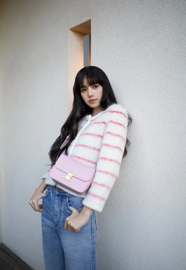 Ảnh lisa dễ thương có một người phụ nữ đứng cạnh bức tường với chiếc ví màu hồng