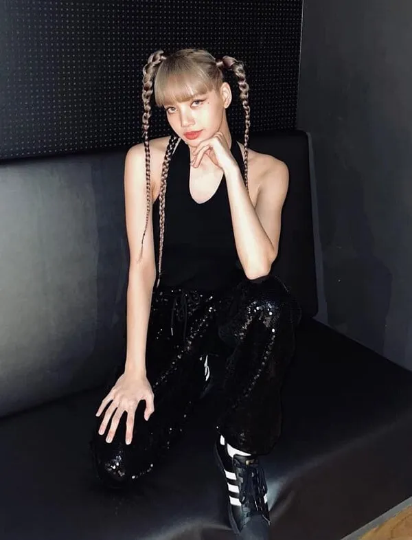 Ảnh lisa dễ thương người phụ nữ tóc vàng với bím ngồi trên băng ghế màu đen trong phòng