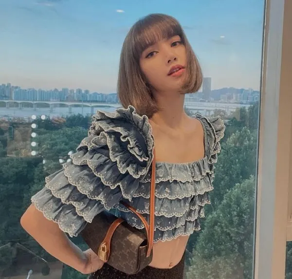 Ảnh lisa blackpink có một người phụ nữ đang đứng trước cửa sổ
