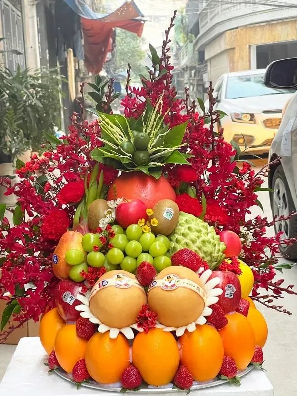 Ảnh mâm ngũ quả có một màn hình lớn của trái cây và hoa trên đường phố