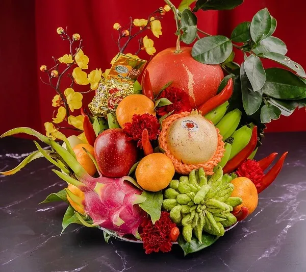 Ảnh mâm ngũ quả một số trái cây và rau được sắp xếp trong cái bát trên bàn
