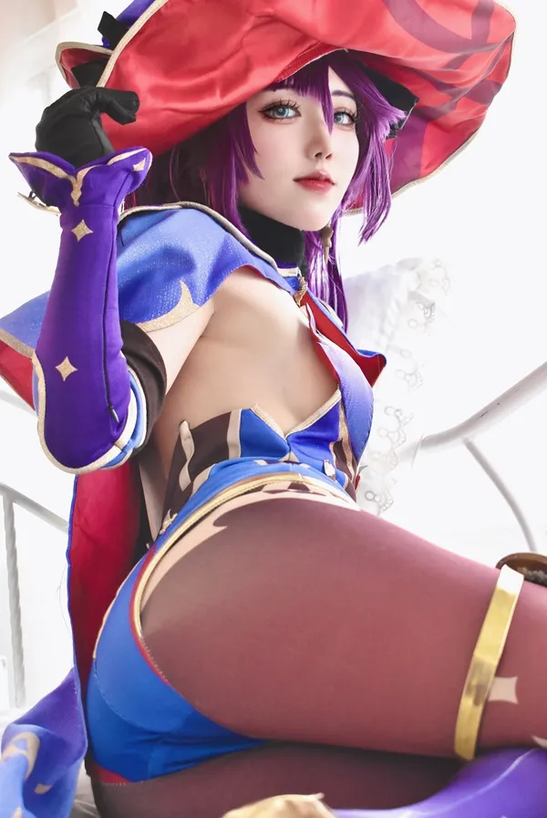 Ảnh mona cosplay anime của một cô gái với mái tóc màu tím đội mũ đỏ và váy xanh