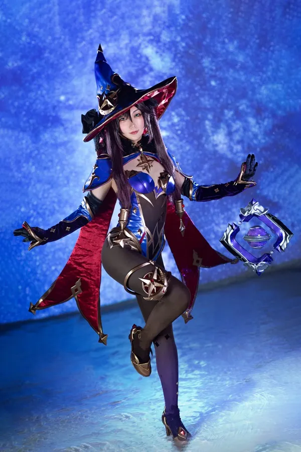Ảnh mona cosplay có một người phụ nữ ăn mặc như phù thủy với chiếc mũ và áo choàng