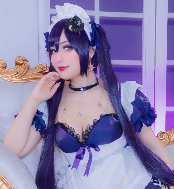 Ảnh mona cosplay có một người phụ nữ mái tóc đen dài ngồi trên chiếc ghế