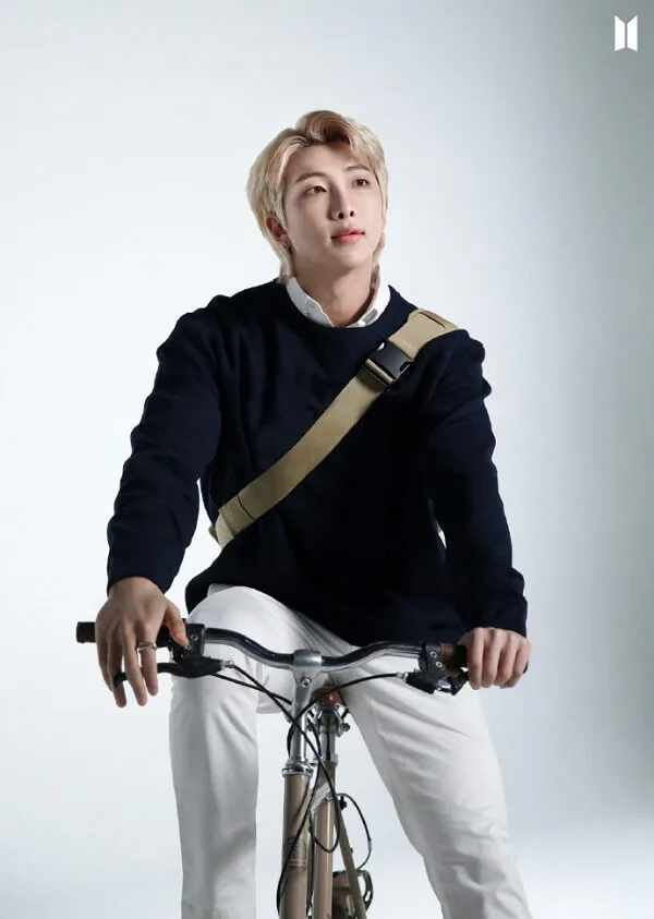 Ảnh rm bts có một người đàn ông đang ngồi trên chiếc xe đạp tạo dáng cho bức tranh