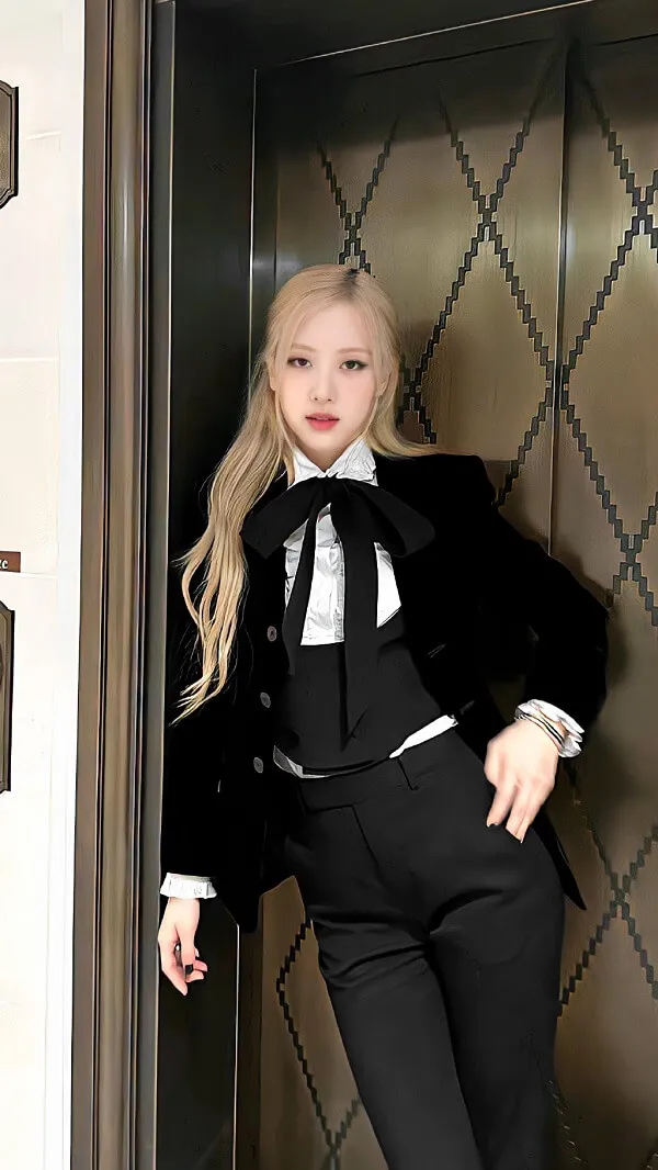 Ảnh rose cute người phụ nữ tóc vàng mặc bộ đồ đen và áo sơ mi trắng đang đứng trong thang máy