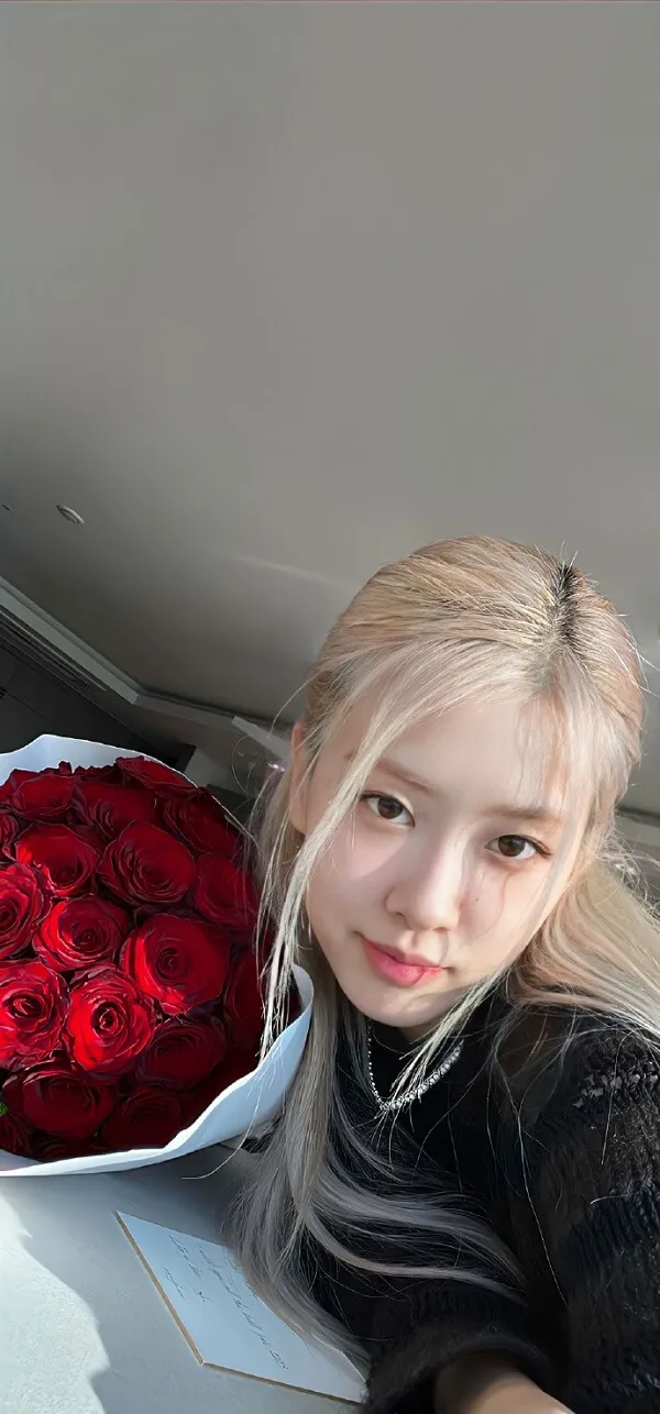 Ảnh rose blackpink đẹp có một người phụ nữ cầm bó hoa hồng đỏ trên sàn nhà