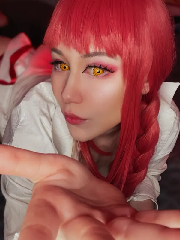 Ảnh sex cosplay makima có một người phụ nữ mái tóc đỏ tươi cầm điện thoại di động