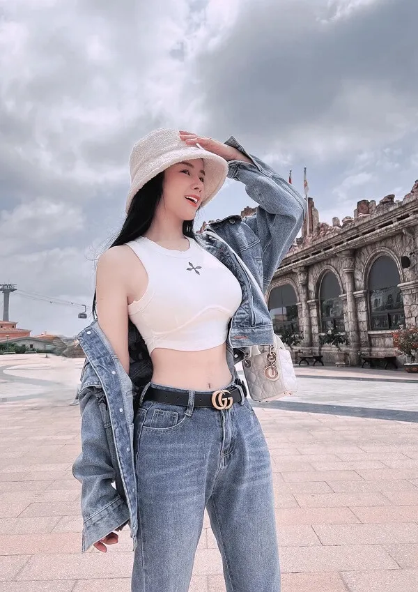 Dj mie có một người phụ nữ đang đứng trên đường mặc quần jean và mũ