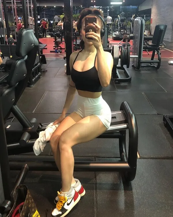 Ảnh sexy của miu lê có một người phụ nữ đang ngồi trên chiếc ghế dài trong phòng tập thể dục