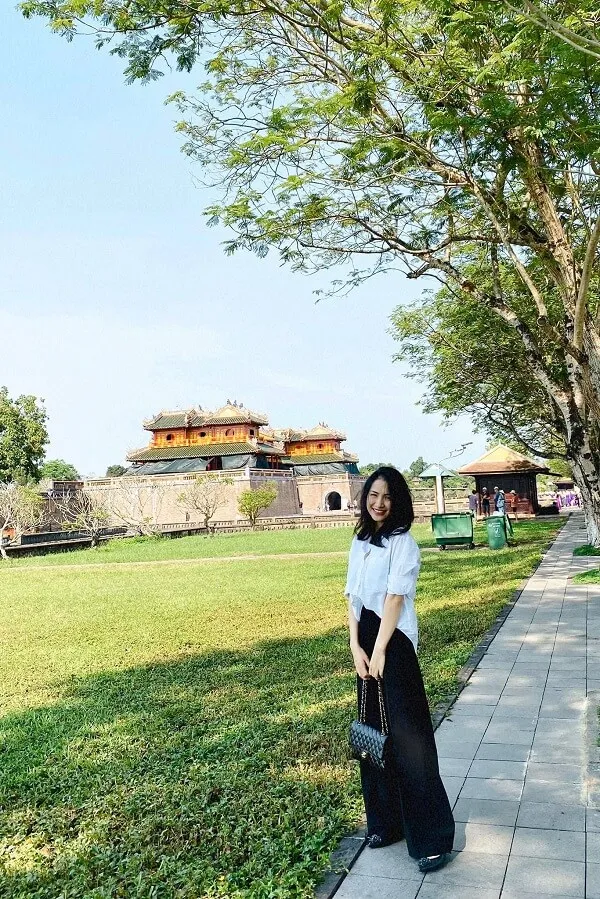 Ảnh hoà minzy có một người phụ nữ đang đứng trên vỉa hè cỏ