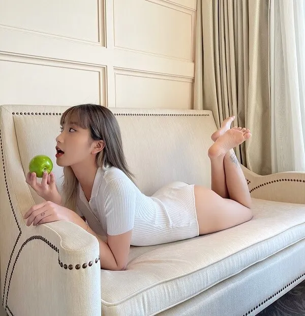 Ảnh sexy lê thị khánh huyền có một người phụ nữ đang nằm trên chiếc ghế dài ăn quả táo