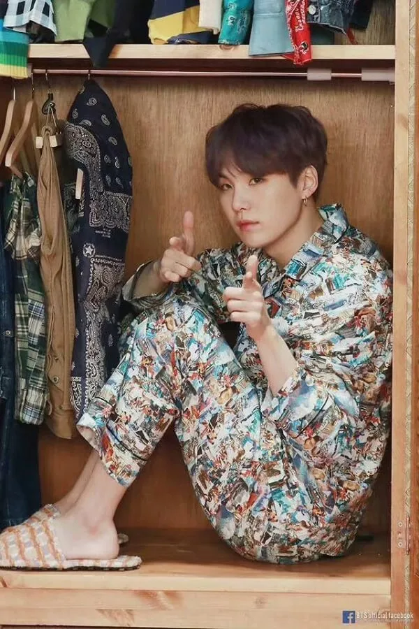 Ảnh suga bts có một người đàn ông đang ngồi trên mặt đất trong tủ quần áo