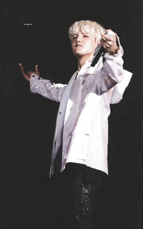 Ảnh suga dễ thương có một người đàn ông mặc áo sơ mi trắng và quần đen cầm điện thoại di động