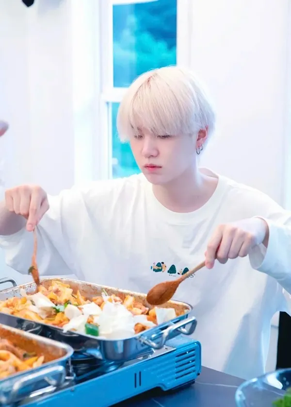 Ảnh suga bts có một cậu bé đang ngồi bàn với ít thức ăn