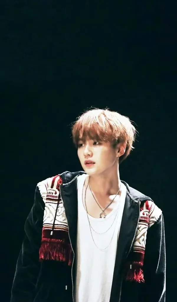 Ảnh suga bts có một người đàn ông đang đứng trong bóng tối với hai tay túi