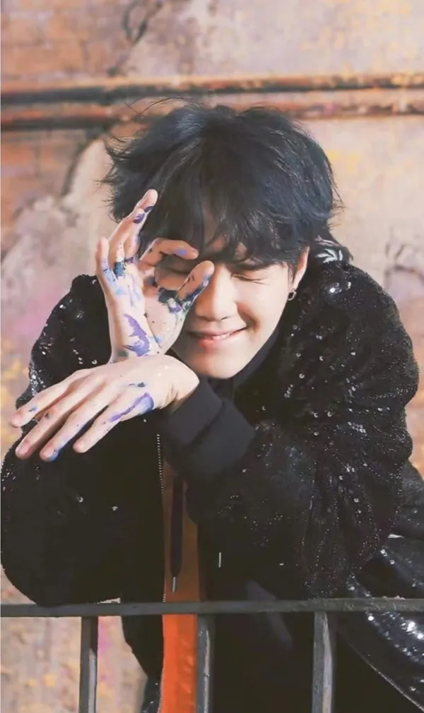 Ảnh suga bts có một người đàn ông đang giơ tay lên mặt