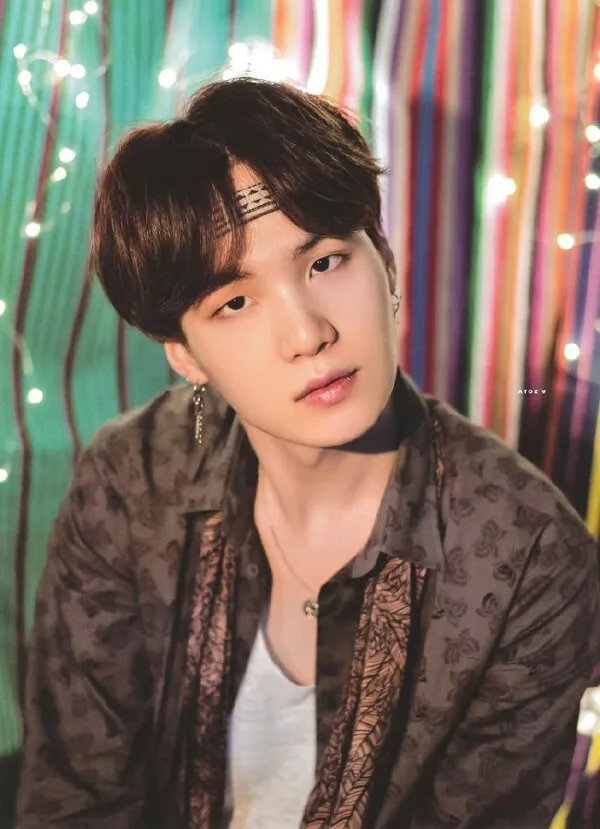 Ảnh suga dễ thương cận cảnh một người mặc áo khoác và vòng cổ