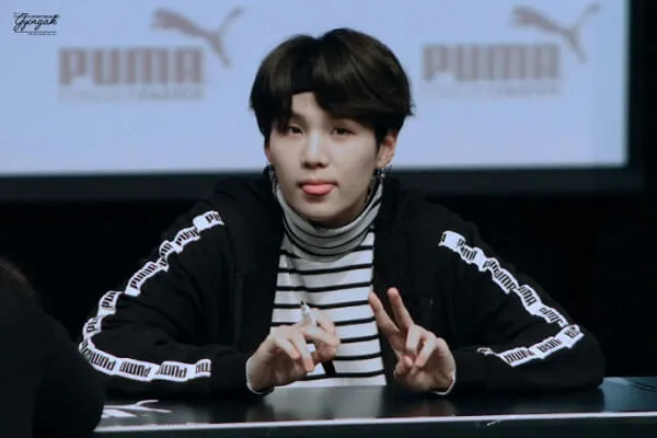 Ảnh suga cute có một chàng trai trẻ ngồi bàn trước màn hình