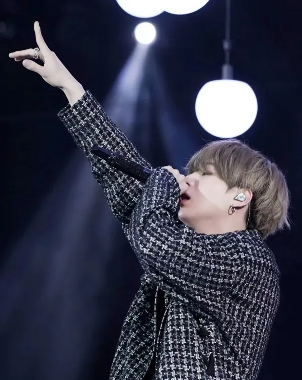 Ảnh suga dễ thương cậu bé đang hát vào micro trên sân khấu