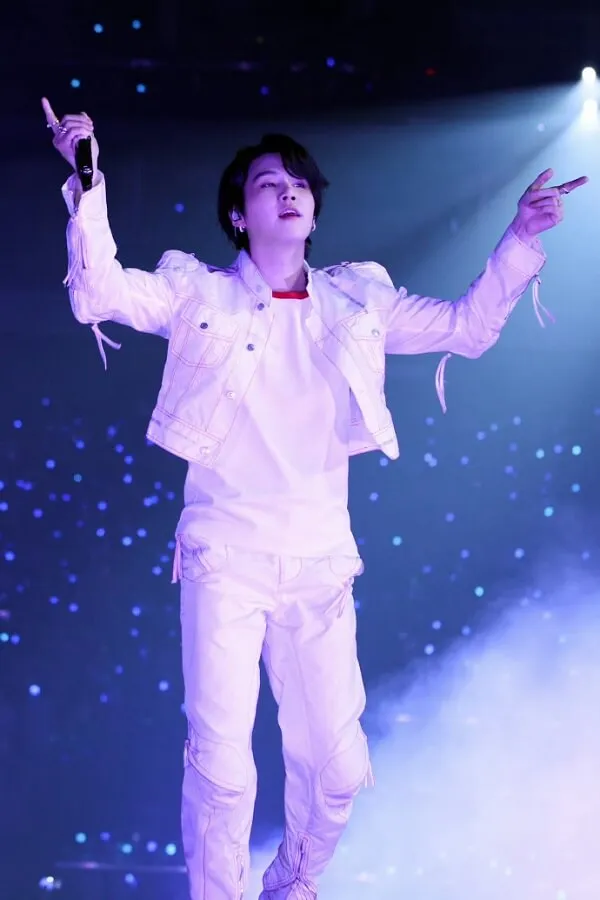 Ảnh suga dễ thương có một người đàn ông đang đứng trên sân khấu với micro