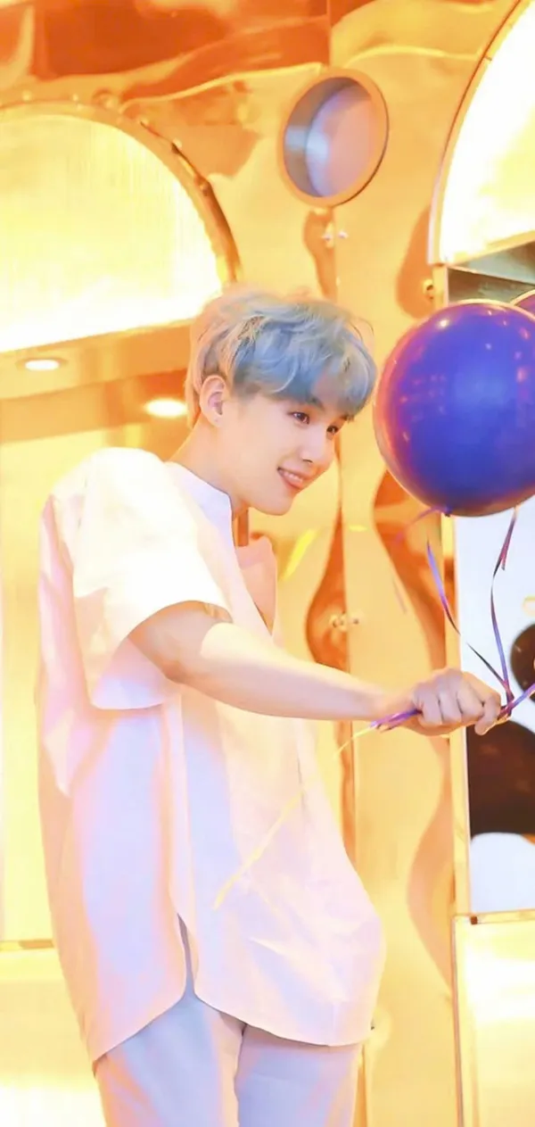 Ảnh suga ngầu có một người đàn ông mặc áo sơ mi trắng cầm khinh khí cầu