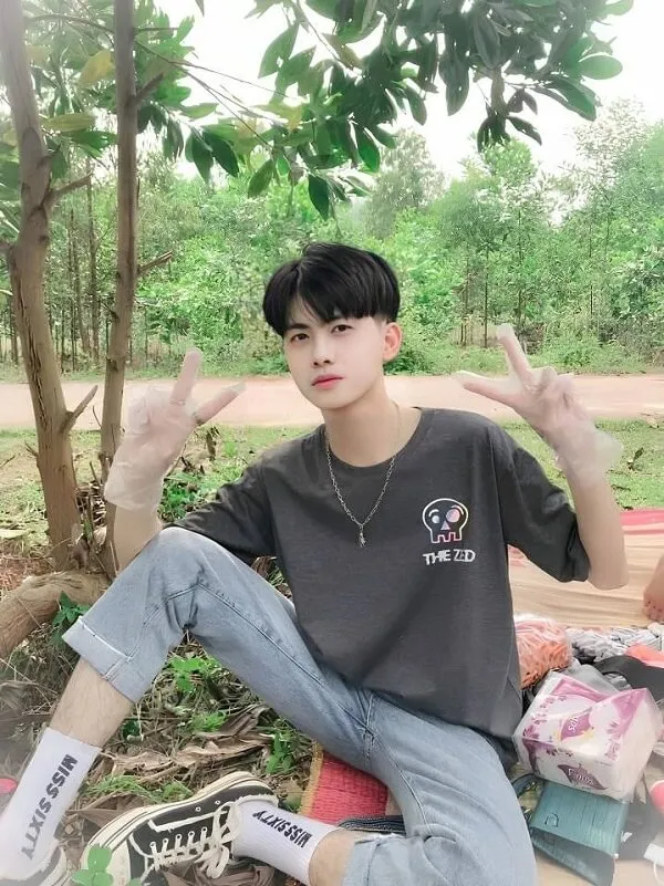 Hình ảnh trai đẹp 12 tuổi có một người đàn ông ngồi trên mặt đất với đôi tay trong không khí